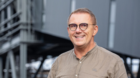 man in front of company building